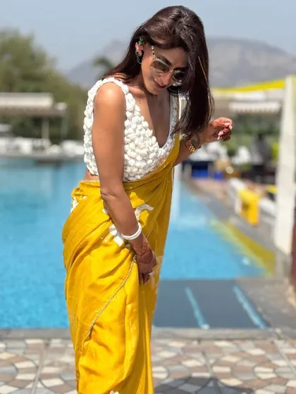 A candid moment showing the beautiful drape of the organza saree. The way the fabric falls and moves is a key part of its elegance. This is something I always consider when helping clients choose their sarees.