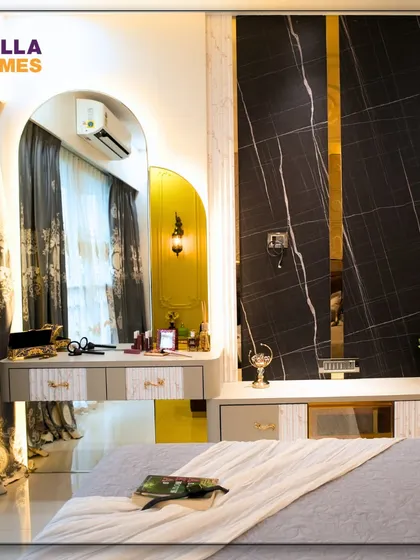 The dressing and TV unit in the Parisian bedroom. The design combines a classic vanity mirror with modern black marble and gold accents.