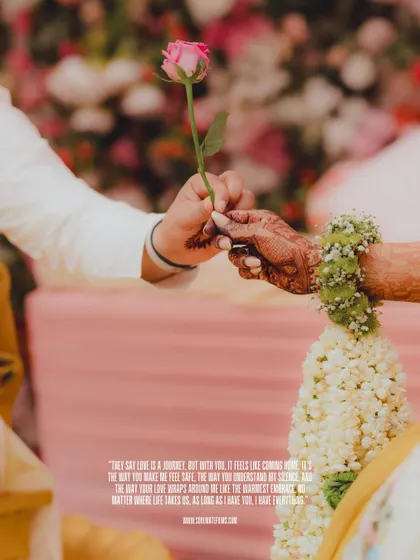 A symbolic and romantic detail shot from a Haldi ceremony. The groom offers the bride a single rose, a tender moment amidst the celebrations.