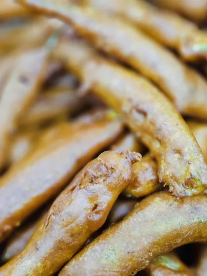 Crispy fried baby corn or a similar vegetable pakora, a crunchy and addictive starter.