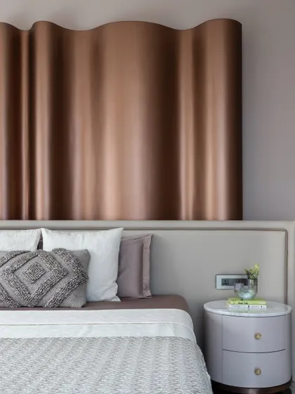 A detail of the wavy, metallic headboard in 'The House of Arcs', which creates a sense of harmony and fluidity.