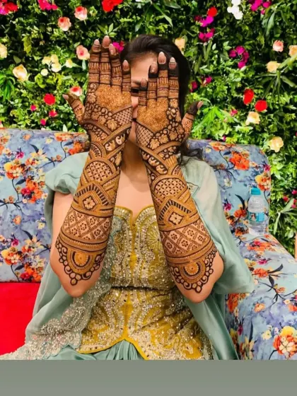A bride playfully hiding behind her beautifully done hands.