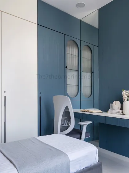 This image shows the integrated study desk that seamlessly transforms into a dresser, complete with a mirror. The wardrobe features long handles and a dedicated corner for books and bags.