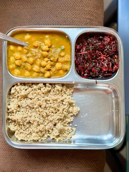 A gluten-free and protein-rich meal of foxtail millet, chana masala, and sautéed amaranth leaves.