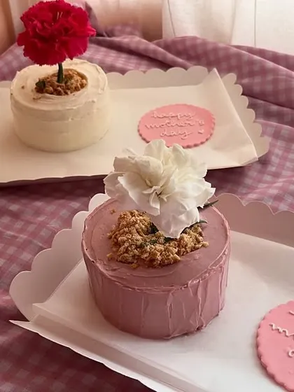 For Mother's Day, I made these super cute flower pot bento cakes. They come with a real carnation on top and a little cookie that says 'Happy Mother's Day'. It’s a sweet and unique way to show your love.