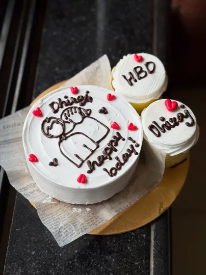 A lovely personalized birthday set for Dhiraj. The bento cake features a cute couple illustration, and the two cupcakes are customized with "HBD" and his name.