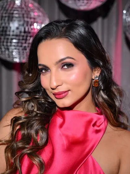 A close-up of the hot pink dress look, focusing on the flawless makeup with a pop of color on the lips and cheeks.