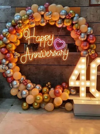 A cozy and intimate setup for a 40th-anniversary celebration at home. The circular balloon arch and marquee numbers create a festive focal point.