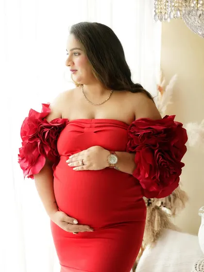 A stunning solo portrait of the mother in a dramatic red gown, capturing her strength and beauty as she awaits baby number two.