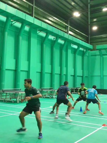 Agility and reaction time are critical in badminton. This image shows athletes at a training camp working on multi-directional movement drills, designed to improve their on-court speed and responsiveness.