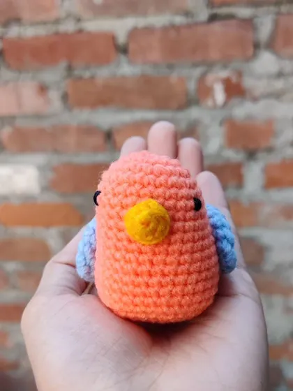 The front view of the little orange bird plushie.