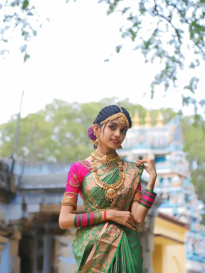 A full-length view of the green and pink bridal saree, showing how gracefully it drapes. This rental is a popular choice for muhurtham ceremonies.