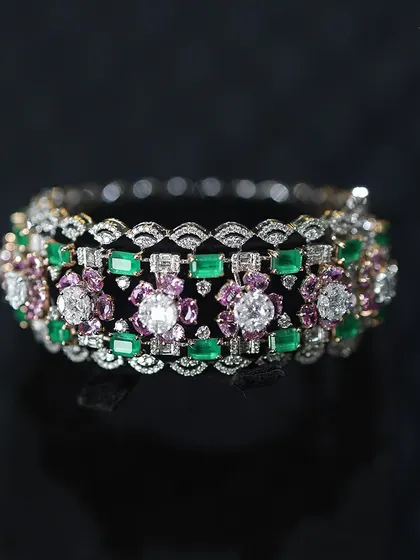 Intricately crafted with endless glamour, this diamond bracelet with emerald and pink stones is a perfect piece to stack or wear as a standalone statement.