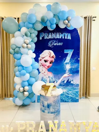 A simple yet elegant Frozen theme decoration, perfect for home celebrations. This setup features a custom backdrop with Elsa, a beautiful balloon arch, and light-up letters for the birthday girl's name.