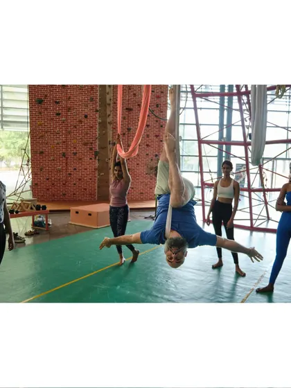 An instructor demonstrates an open-arm inversion, a wonderful pose for opening the chest and shoulders while enjoying the benefits of being upside down.