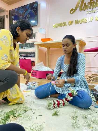 A trainer providing individual guidance during the hands-on flower-making session.
