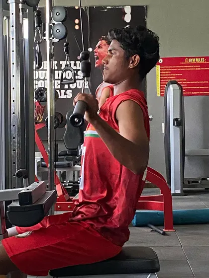 A player focuses on a lat pulldown exercise. A strong back and core are essential for stability, balance, and injury prevention in football.