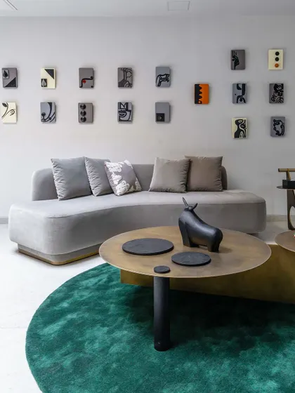 The full installation of abstract painted blocks in the 'House of the Rising Sun' project, arranged as a gallery wall above a modern sofa.