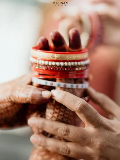 A detail shot of the bride's hands holding her bangles, a mix of Odia and Telugu traditions. Capturing these blended details is key to telling the story of an inter-cultural wedding.