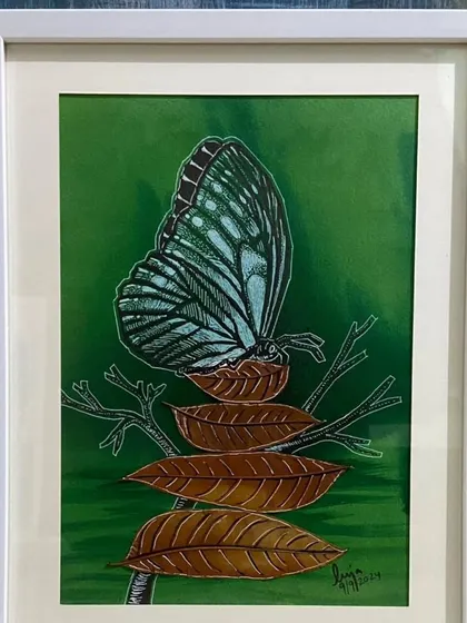 This sold artwork by Puja Kumari features a beautiful blue butterfly on dried leaves. The success of her exhibition highlights the community's support for innovative and nature-inspired art.