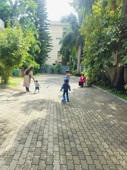 A wide view of a skating lesson in a beautiful, green residential area. A parent and younger sibling watch on, showing how our classes can become a family activity.