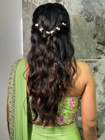 A simple yet beautiful half-up hairstyle. The soft waves are accented with delicate pearl clips, making it a perfect look for a bridesmaid.