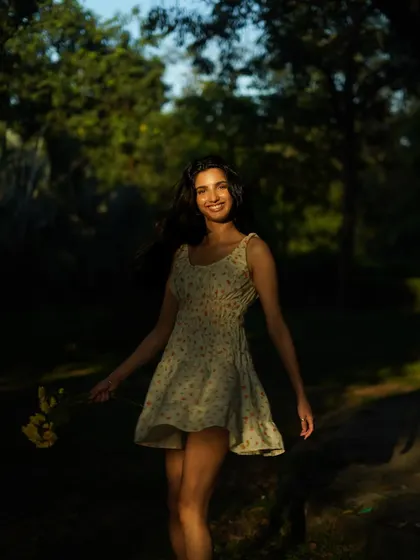 Playing with light and shadow in a natural setting. The way the sun highlights her face while the background remains dark creates a beautiful, focused portrait.