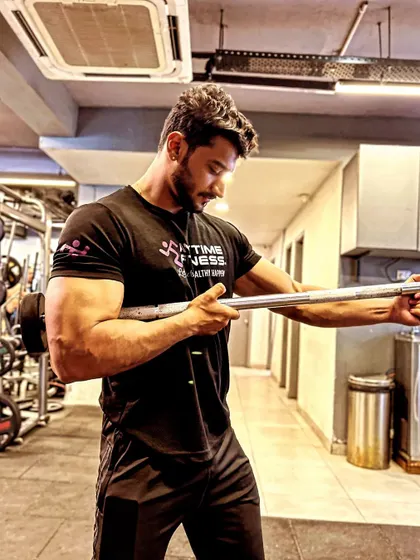 A candid shot holding a barbell, as a coach at Anytime Fitness.