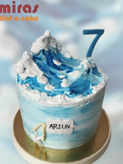 A stunning cake that captures the power and beauty of an ocean wave. The top is sculpted with blue and white buttercream to create a cresting wave, perfect for a 7th birthday.