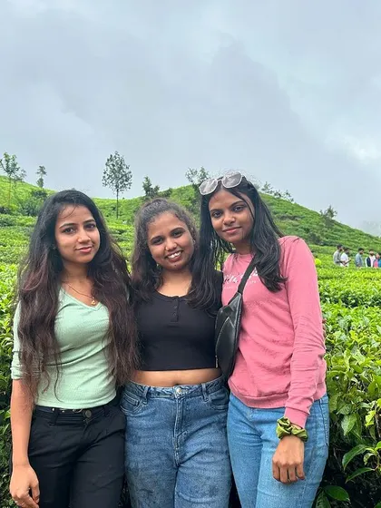 Three friends posing amidst the lush greenery of the Samse Tea Estate.