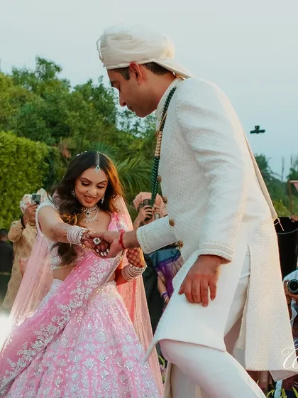 The groom lovingly helps his bride onto the stage during her entrance.