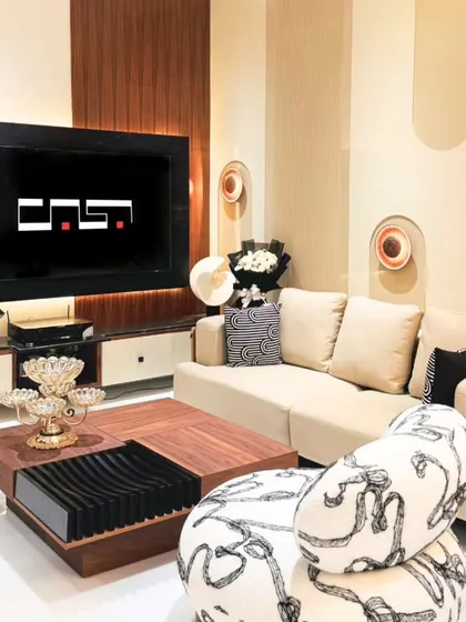 Another living area design, this one featuring a comfortable beige sofa, a unique patterned armchair, and a functional coffee table with built-in storage.