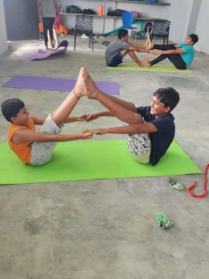 The joy of accomplishment is clear on their faces as these two campers hold a steady partner boat pose.