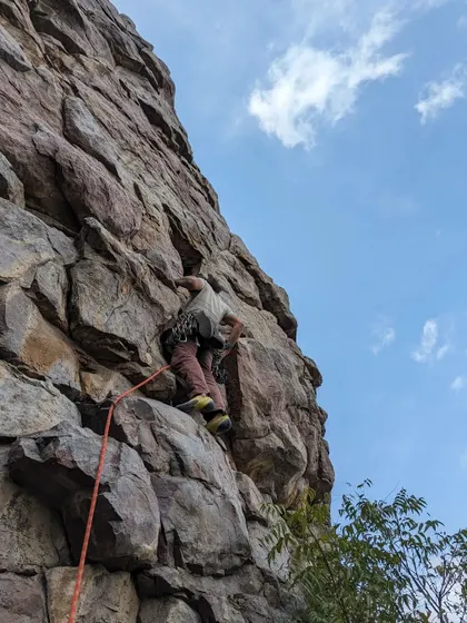 A close-up shot of a climber navigating a challenging section of a sport route. Roped climbing requires endurance, technique, and a whole lot of trust in your gear and your partner.