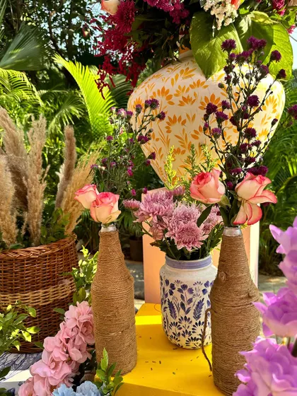 A close-up of the Dior-themed decor, showing rustic jute-wrapped bottles, floral arrangements, and other charming, handcrafted details.