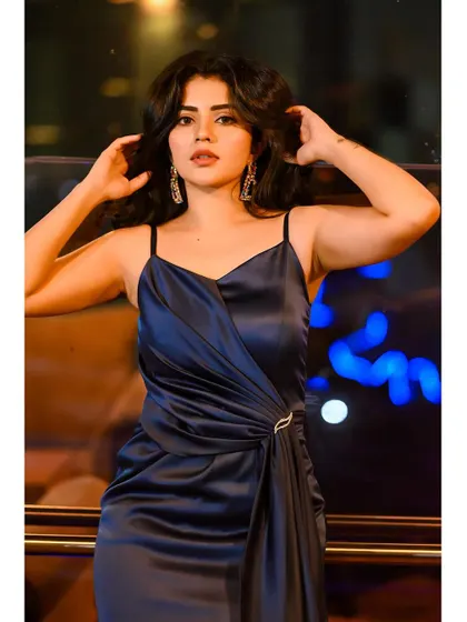 The stunning actress Pavithra Gowda wearing a custom navy blue satin gown. The draped silhouette and spaghetti straps create a look of modern, understated glamour.