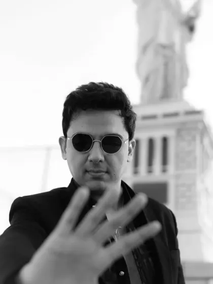A creative black and white portrait with a shallow depth of field. The hand in the foreground adds an artistic and engaging element to the shot.