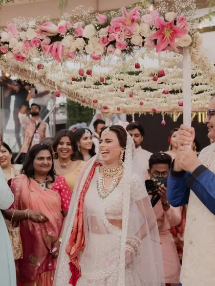 A joyous bridal entry under a beautiful 'phoolon ki chadar' held by her loved ones. We coordinate these traditions to be seamless and full of emotion.
