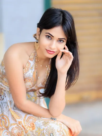 A charming and relaxed seated portrait. Her gentle smile and natural pose make this a warm and inviting image.