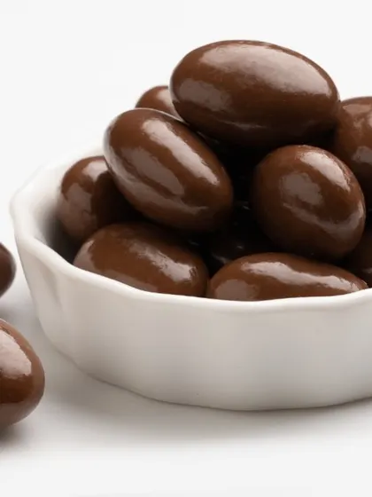 A bowl of our chocolate-coated almonds. We take whole roasted almonds and cover them in a thick layer of smooth, dark chocolate for a classic combination of crunchy and sweet.