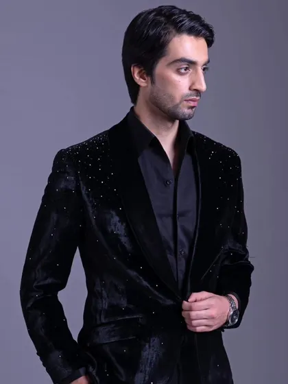Elevate your style game effortlessly. This black velvet jacket with subtle crystal embellishments on the shoulders offers the perfect blend of sophistication and modern flair.
