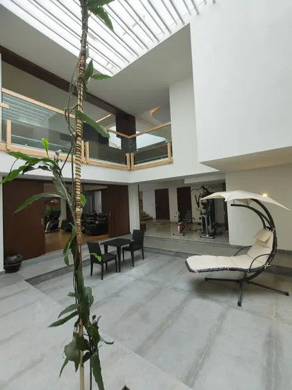 The central courtyard garden in a residence, showcasing a juxtaposition of different volumes. The upper-level bridge overlooks the open space below, which is designed as a tranquil internal retreat.