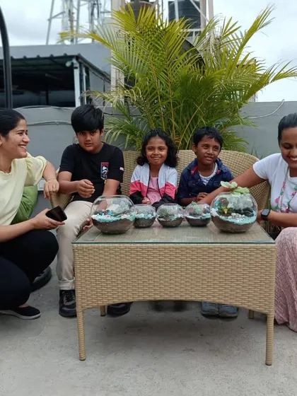A family poses with the four unique terrariums they created together. This is a fantastic weekend activity that the whole family can enjoy.