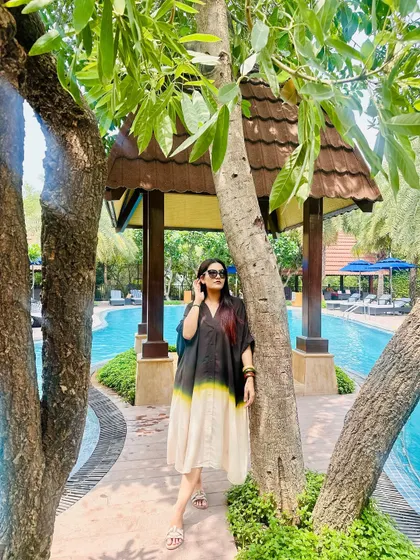 Lounging by the pool in my black, yellow, and cream tie-dye kaftan. It's the epitome of relaxed vacation style.