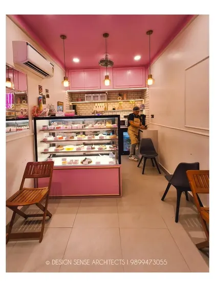 This shot shows the full interior from the entrance. Despite its narrow layout, the space feels bright and organized, with clear zones for display, service, and seating.