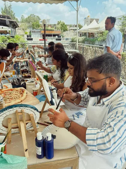 A group of friends enjoying a paint party on a rooftop. The combination of art, food, and a great view makes for an unforgettable experience.