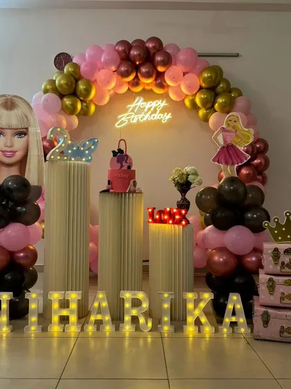 Come on Barbie, let's go party. This Barbie-themed setup for Niharika is all about pink and glam, with large character cutouts, a pink and gold balloon arch, and themed props.