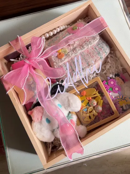 The fully assembled hamper for a young girl, packed in a wooden box and tied with a pretty pink bow.