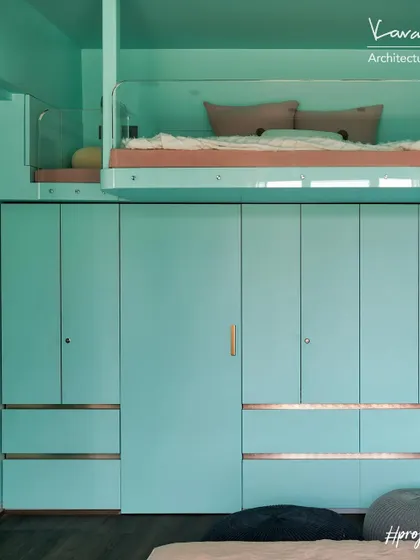 The loft bed in Project 704 is integrated with a full wall of wardrobe storage below. One of the wardrobe doors is a secret entrance to the bathroom, keeping the room's design clean and adding an element of fun.