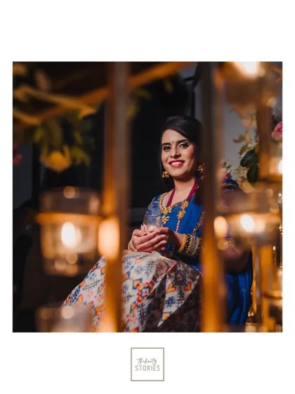 A framed portrait of the bride seen through a lattice of candles, a creative shot that adds depth and warmth.